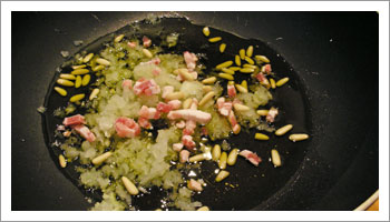In un largo tegame, versa una buona dose di olio di oliva, e versaci la cipolla e 

l'aglio tritato, la pancetta tagliata a dadini e una quindicina di pinoli interi. Fai rosolare il tutto.