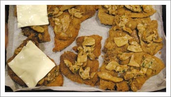 Affianca le cotolette sulla teglia e condiscine la superficie con uno strato di funghi e termina con una sottiletta.