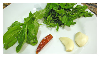 Prepara un trito di prezzemolo, basilico, lo spicchio di aglio e il peperoncino