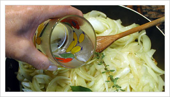Metti in una tegame 1/2 kg. di cipolle tagliate fini con un goccio d'olio, la maggiorana, l'alloro, il brodo granulare e un bicchiere di acqua