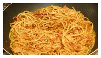 Aggiungi gli spaghetti avendo cura di pressarli per dargli una forma compatta