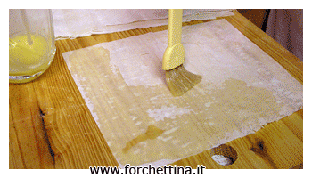 Versa del composto di verdure sopra il foglio di pasta filo appena preparata, piega dalla parte della lunghezza e arrotola.