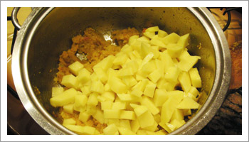 Non appena si colora, aggiungi le patate tagliate a cubetti