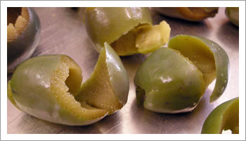 denocciolate le olive verdi con il 
coltello. Tagliate a spirale partendo da una estremità e facendo attenzione a non spezzarla
