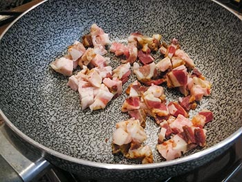 Fai rosolare il guanciale in una padella antiaderente fino a che il suo grasso non si sarà sciolto e i pezzi  non saranno un po croccanti.