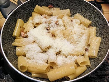 Aggiungi un abbondante macinata di pepe e il guanciale che hai tenuto da parte e mescola di nuovo. Spengi la fiamma e versa il pecorino mescolando.