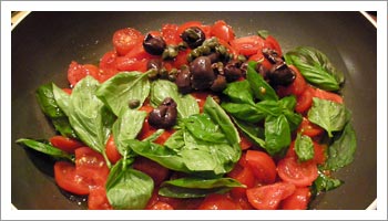 Aggiungi i pomodori tagliati a  quarti, il basilico sminuzzato a mano, le olive snocciolate, i 
capperi precedentemente privati del sale di conserva, e pochissimo sale