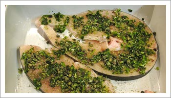 Cospargi la superficie del pesce spada con il prezzemolo, il basilico, l'aglio e la cipolla, tutti tritati 

in modo medio/fine.