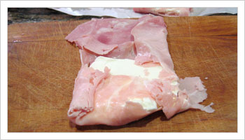 Dividi la mozarella in fettine e avvolgici attorno il prosciutto