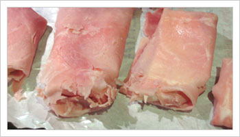 Dividi la mozarella in fettine e avvolgici attorno il prosciutto