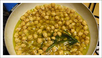 Metti a soffriggere in un tegame l'olio con l'aglio schiacciato in camicia. Aggiungi i ceci e un rametto di rosmarino; mescola e 

poi continua la cottura coprendo i ceci con l'acqua di cottura del baccala.