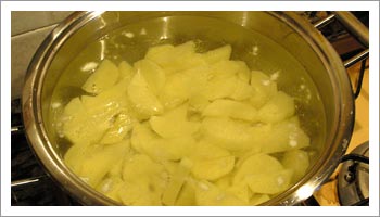 Pela le patate, passale sotto l'acqua corrente e cuocile in una pentola capiente con abbondante acqua già salata