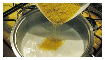 Porta il latte ad ebollizione in una casseruola, versaci il riso.