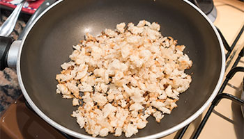 tosta in una padella la mollica di pane sgranata con un filino di olio di oliva