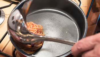 Prepara dei nidi di pasta aiutandoti con forchetta e un mestolo