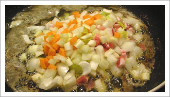 Nello stesso recipiente di cottura, fai imbiondire la cipolla, il sedano e la carota e dopo qualche minuto la pancetta.