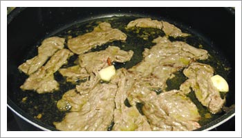Metti l'aglio e il peperoncino in una padella e fai 

imbiondire in olio extravergine di oliva. Scotta appena la carne, e insaporiscine la superficie con sale, pepe, zenzero e paprika.