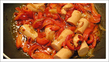 Aggiungi ai pomodori i peperoni fritti, mescola e aggiungi anche i w�rstel tagliati a tocchetti.