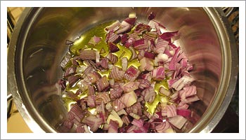 Trita le cipolle e sistemale sul fondo di una pentola con dell'olio di oliva