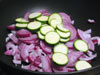Taglia a rondelle le zucchine con le cipolle